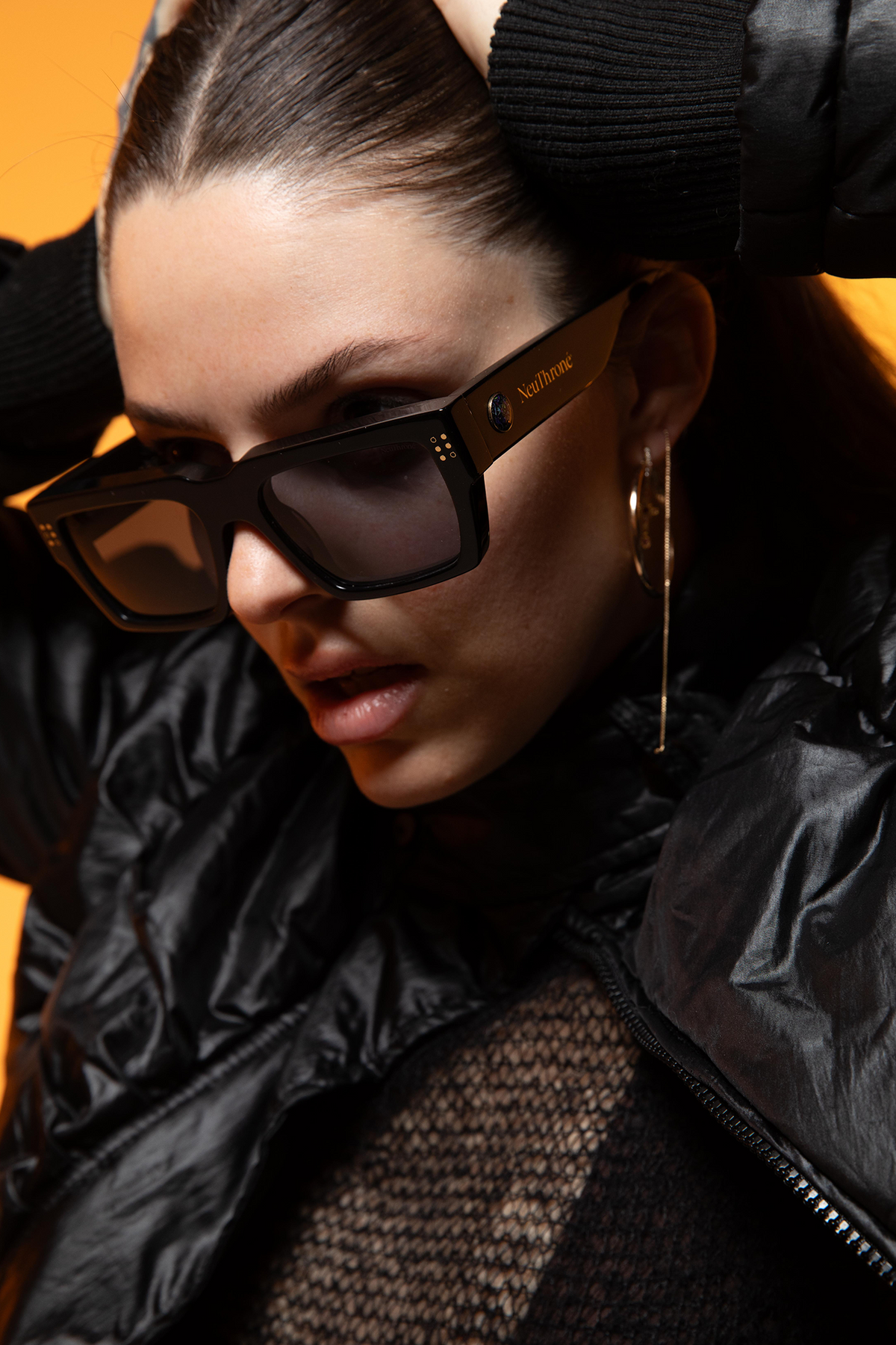 Women wearing a black puffer jacket and sunglasses with a blurred background